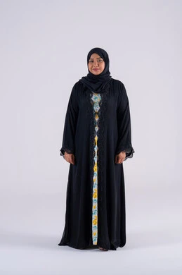Emphasis on elegance and attention to one's outward appearance. A Saudi woman looks with expressions of pleasure and happiness. A portrait of an Arab Gulf Emirati woman wearing an abaya and hijab, standing with gestures of self-confidence.