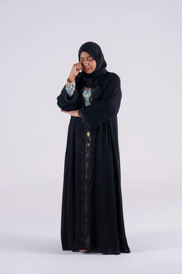 القلق والحيرة في اتخاذ القرار الصحيح، محاولة إيجاد حل للمشكلات الصعبة، التفكير بعمق وشرود الذهن، بورتريه لامراه عربيه خليجيه اماراتيه ترتدي العباءه والحجاب تضع يدها أسفل ذقنها ، سيده سعوديه تقف بإيماءات الحيرة