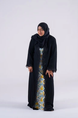 Bone and joint pain, a Saudi woman feeling tired and exhausted, the need for treatment and a visit to the doctor, feeling pain in the knee, a portrait of an Arab Gulf Emirati woman wearing an abaya and hijab, placing her hands on her leg with an expression of pain.