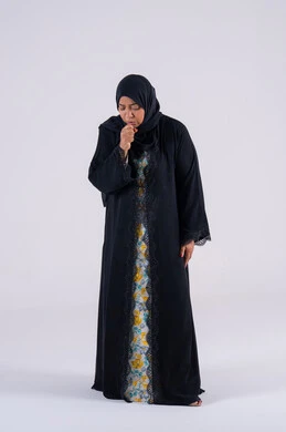 Feeling sick and coughing, portrait of an Arab Gulf Emirati woman wearing an abaya and hijab suffering from a cough, influenza, and pneumonia, infected with the coronavirus, a Saudi woman feeling tired and exhausted.