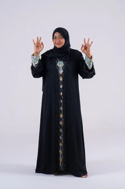 التعبير عن الجودة والاتقان، سيده سعوديه تشير بتعابير الرضي والموافقة ، البشاشة والشعور بالسعادة ، بورتريه لامراه عربيه خليجيه اماراتيه ترتدي العباءه والحجاب تقوم برفع ايديها بإيماءات الجودة والامتياز والتميز