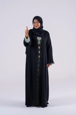 Portrait of an Arab Gulf Emirati woman wearing an abaya and hijab raising her hands in gestures of quality, excellence, and distinction, expressing quality and perfection. A Saudi woman gestures with expressions of satisfaction, approval, cheerfulness, and happiness.