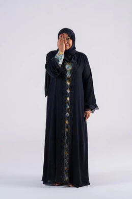 ايماءات قياس النظر  ، بورتريه لامراه عربيه خليجيه سعوديه ترتدي العباءه والحجاب تضع يدها على نصف وجهها بتعابير فحص العين ، سيده اماراتيه تحتاج للكشف الطبي