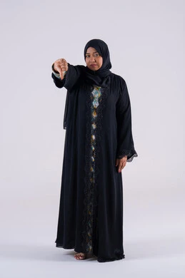 الإشاره بأصبع الإبهام لأسفل, الإنزعاج من شيء ما ، بورتريه لامراه عربيه خليجيه اماراتيه ترتدي العباءه والحجاب تقفف بايماءات يد تدل على عدم الموافقه  وعدم الإعجاب والرفض