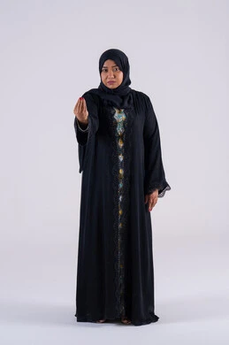 الهدوء وطلب التوقف، بورتريه لامراه عربيه خليجيه اماراتيه ترتدي العباءه والحجاب وتنظر الى الكاميرا بسرور وسعادة، سيده سعوديه تشير بإيماءات الصبر والتأن والتريث، إمهال الوقت والإنتظار للقيام بشيء ما