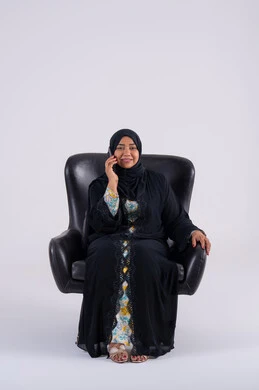 الدردشة والتحدث مع الأصدقاء، اجراء مكالمه هاتفيه ،تصفح مواقع وتطبيقات الانترنت، بورتريه لامراه عربيه خليجيه اماراتيه ترتدي العباءه والحجاب تجلس على كرسي ، تمسك الجوال بيدها، سيده سعوديه تستخدم التقنيات والتكنولوجيا الحديثة بالحياة اليومية