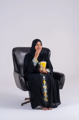 ايماءات التعجب والدهشة،  انشطة ترفيهية منزلية،سيده سعوديه تتناول الفوشار والمشروبات الباردة، بورتريه لامراه عربيه خليجيه اماراتيه ترتدي العباءه والحجاب ، تستمتع بمشاهدة الأفلام والمسلسلات، متابعة برامج التلفاز، قضاء وقت ممتع في المنزل