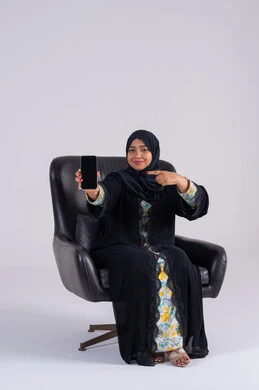Browsing websites and applications, viewing a mobile phone screen, chatting and talking with friends, a portrait of an Arab Gulf Emirati woman wearing an abaya and hijab holding a mobile phone, a Saudi woman using modern technologies in daily life. Browsing websites and applications, viewing a mobile phone screen, chatting and talking with friends, a portrait of an Arab Gulf Emirati woman wearing an abaya and hijab holding a mobile phone, a Saudi woman using modern technologies in daily life.