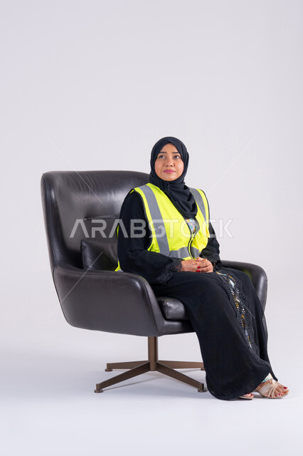 مفهوم الهندسة والانشاءات المعمارية، العمل في القطاع الهندسي، سيده اماراتيه تنظر بايماءات الفخر، تعابير السرور والسعادة والثقة بالنفس،بورتريه لمهندسة عربية خليجية سعودية محجبة ترتدي سترة الحماية