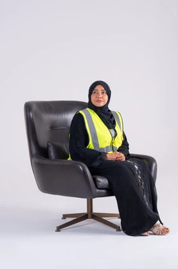 مفهوم الهندسة والانشاءات المعمارية، العمل في القطاع الهندسي، سيده اماراتيه تنظر بايماءات الفخر، تعابير السرور والسعادة والثقة بالنفس،بورتريه لمهندسة عربية خليجية سعودية محجبة ترتدي سترة الحماية