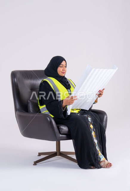 الاشراف والرقابة على المشاريع الهندسية ، سيده سعوديه تقوم بتطوير المشاريع الهندسية في المملكة العربية السعودية على يد أبنائها, بورتريه لمهندسة عربية خليجية اماراتيه محجبة ترتدي سترة الحماية تحمل بيدها مخططات الاعمار