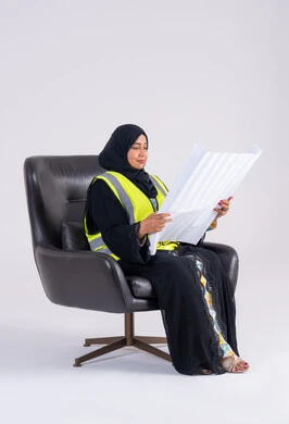 الاشراف والرقابة على المشاريع الهندسية ، سيده سعوديه تقوم بتطوير المشاريع الهندسية في المملكة العربية السعودية على يد أبنائها, بورتريه لمهندسة عربية خليجية اماراتيه محجبة ترتدي سترة الحماية تحمل بيدها مخططات الاعمار