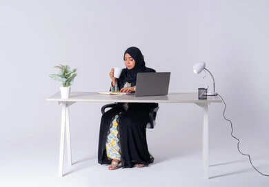 استخدم التقنيات الحديثة في الأعمال الإدارية ، دمج التكنولوجيا المتطوره فى الحياه اليوميه ، التركيز والتفاني والعمل الجاد،التوظيف في المكاتب والشركات ، امراه عربيه خليجيه سعوديه ترتدي العباءه والحجاب تجلس على مكتب وتعمل على جهاز الحاسب المحمول ، سيده اماراتيه تقوم باحتساء المشروبات الساخنه