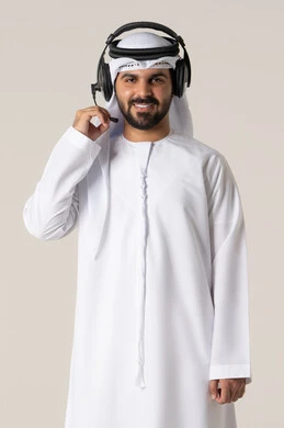 Listening to music and audio, wearing headphones, entertainment and fun using headphone technology, a portrait of an Emirati Gulf Arab man wearing the Emirati kandura, enjoying listening to songs with gestures of joy and happiness, white background.