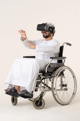 الترفيه عبر تقنيات نظارات الواقع الافتراضي، إيماءات الاندماج والتفاعل مع العالم الخيال، بورترية لشاب عربي خليجي اماراتي من ذوى الاحتياجات الخاصة يرتدي الزي التقليدي و نظارات ثلاثية الأبعاد (الفي ار) يجلس على كرسي متحرك, التطور التقني والتكنولوجي ، خلفية بيضاء