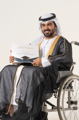 Celebrating the completion of university education, the concept of diligence and excellence, the feeling of joy, pride, and self-confidence, a portrait of an Emirati Arab Gulf student with special needs wearing traditional attire and a black abaya sitting in a wheelchair holding a graduation certificate, looking at the camera with gestures of satisfaction and happiness, white background.