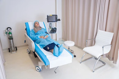 غرفة حديثة لفحص وتشخيص المرضى في المستشفى، جهاز مونيتور لمراقبة حالة السيدة الصحية, مريضة عربية خليجية اماراتية محجبة مستلقية على السرير