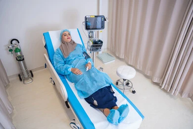 لقطة واسعة لغرفة مستشفى تظهر فيها مريضة عربية خليجية اماراتية محجبة متصلة بالأجهزة الطبية,  موعد مع الطبيب لتلقي العلاج, إجراء الفحوصات والمتابعة الدورية للمرضى