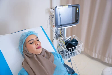 Close-up of a veiled Emirati Gulf Arab woman lying on a hospital bed. Precise treatment procedures are being carried out in a room equipped with the latest medical devices to ensure continuous monitoring of the patient's condition. An appointment with the doctor to receive treatment.
