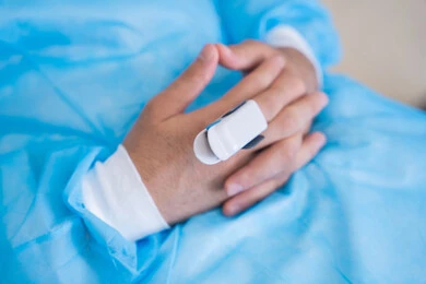 Close-up of a patient's hands in the hospital during a health check-up, monitoring blood oxygen levels, integrating modern technology into the medical field