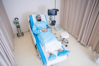 الاستلقاء على سرير المستشفى، متابعة العلامات الحيوية لمريض عربي خليجي اماراتي باستخدام جهاز قياس الأكسجين وضغط الدم, فحص سلامة المؤشرات الحيوية