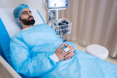 Monitoring the vital signs of an Emirati Gulf Arab patient using a blood pressure and oxygen measuring device, checking the integrity of vital signs in the hospital, integrating modern technology into the medical field.