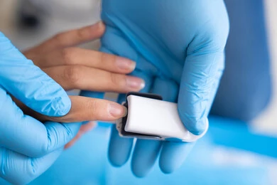 العناية الطبية الحديثة بقياس الأكسجين في الدم, فحص سلامة المؤشرات الحيوية في المستشفى, دمج التكنولوجيا الحديثة في المجال الطبي, طبيب يمسك بيد مريضة و يقوم بالفحوصات اللازمة