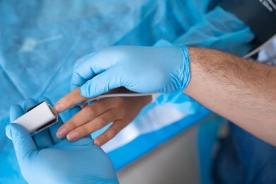Pulse oximeter on patient's finger, checking vital signs in hospital, integrating modern technology into the medical field