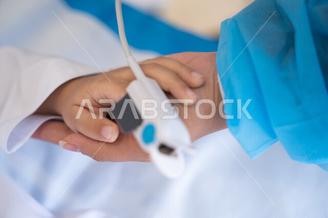 الرعاية الصحية باستخدام جهاز قياس التأكسج, يد مريض صغير أثناء الفحص الطبي, متابعة المؤشرات الحيوية للمريض, مراقبة نسبة الأكسجين في الدم