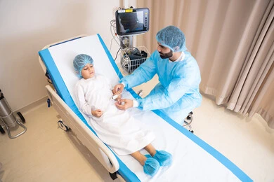 العمل في القطاعات الصحية, عيادات ومراكز صحية متطورة, طبيب عربي خليجي اماراتي يرتدي المريول الطبي يعمل في المستشفى و يقوم بفحص الولد المريض