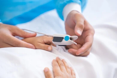 مراقبة نسبة الأكسجين في دم المريض, دمج التكنولوجيا الحديثة في المجال الطبي، يد طبيب يفحص ولد صغير, قياس العلامات الحيوية