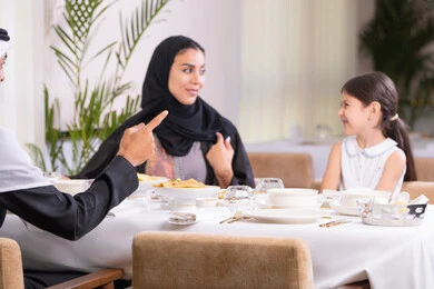 وقت الغداء خارج المنزل، الذكريات واللحظات العائلية السعيدة، عائلة عربية خليجية إماراتية يقومون بتناول الطعام في مطعم راقي ، التفاهم والتواصل الفكري، طاولة مليئة بأطباق الأطعمة الغربية، الاستمتاع في عطلة نهاية الأسبوع