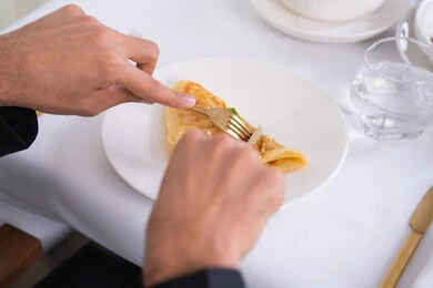 A pie made from baked liquid dough, Levantine Arabic cuisine, a delicious and healthy breakfast, the art of presenting desserts in restaurants in the Kingdom of Saudi Arabia, delicious cold desserts, a plate of delicious crepe decorated with nuts, foods rich in sugars and calories