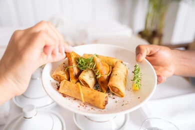 Pieces of golden samosa, close-up of a plate of crispy fried pancakes decorated with herbs, delicious oriental Arabic recipes and dishes, delicious Ramadan appetizers, food presentation techniques in Saudi Arabian restaurants, traditional oriental foods