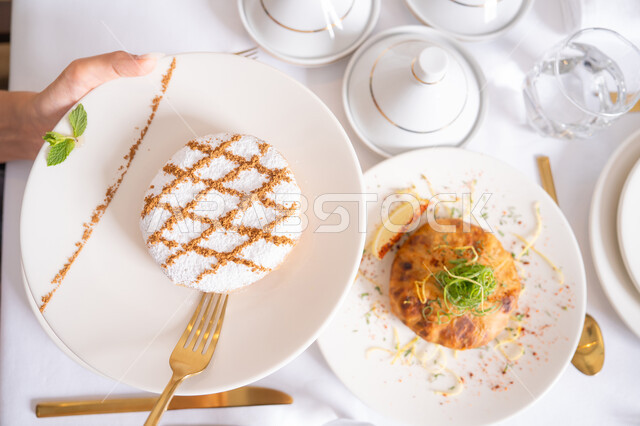 قرص غريبة اللوز المزين بالسكر المرشوش الناعم، قطع المعمول المحشو، الحلويات الشعبية الهشة اللذيذة، الضيافة التقليدية في الأعياد والمناسبات السعيدة، مأكولات غنية بالسكريات والسعرات الحرارية، حلويات مخبوزة بنكهات شهية, منتجات ومأكولات محلية وطنية.