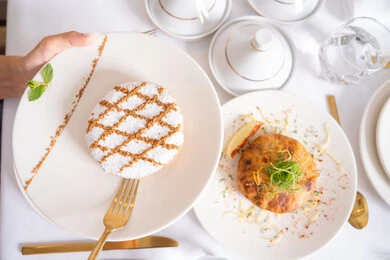 Almond ghriba discs decorated with finely sprinkled sugar, stuffed maamoul pieces, delicious, soft, popular sweets, traditional hospitality during holidays and happy occasions, foods rich in sugar and calories, baked sweets with delicious flavors, local national products and foods.