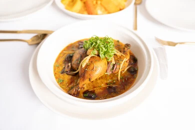 مطاعم المملكة العربية السعودية, وصفات طعام المطبخ السعودي، المأكولات الشرقية الشهية, وجبات وأطباق عربية تقليدية شعبية, صورة علوية عامودية لطبق من أفخاذ الدجاج بالكاري والتوابل المزين بالأعشاب