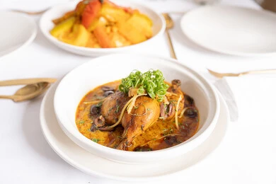 وصفات طعام المطبخ السعودي، المأكولات الشرقية الشهية, مطاعم المملكة العربية السعودية, وجبات وأطباق عربية تقليدية شعبية, صورة علوية عامودية لطبق من أفخاذ الدجاج بالكاري والتوابل المزين بالأعشاب