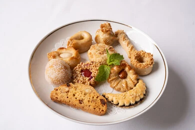 Deliciously flavored baked sweets, the art of serving desserts in the Kingdom's restaurants, a plate of crisp biscuits and fresh traditional sweets, foods rich in sugar and calories, a delicious and healthy breakfast, and local national products and foods.