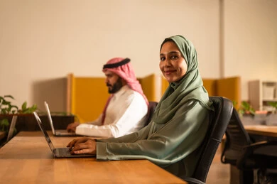 مفهوم المساواة بين المرأة والرجل،  تطوير المشاريع و الاستثمارات، دراسة أوراق البيانات الإحصائية, إدارة و تقسيم المهام، فريق عمل عربي خليجي سعودي يقوم بإجراء اجتماع عمل داخل غرفة الاجتماعات في مقر الشركة،  دمج الأجهزة التقنية الحديثة بالأعمال المكتبية