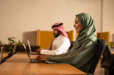 جودة الحياة في الشركات السعودية، تطوير المشاريع و الاستثمارات، دراسة أوراق البيانات الإحصائية, إدارة و تقسيم المهام، فريق عمل عربي خليجي سعودي يقوم بإجراء اجتماع عمل داخل غرفة الاجتماعات في مقر الشركة،  دمج الأجهزة التقنية الحديثة بالأعمال المكتبية