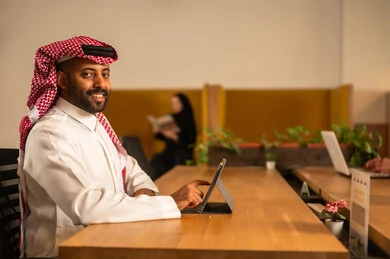 ارتداء اللباس السعودي التقليدي, تطوير المشاريع و الاستثمارات، دراسة أوراق البيانات الإحصائية, إدارة و تقسيم المهام، فريق عمل عربي خليجي سعودي يقوم بإجراء اجتماع عمل داخل غرفة الاجتماعات في مقر الشركة،  دمج الأجهزة التقنية الحديثة بالأعمال المكتبية