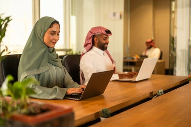 The comfortable work environment in the Saudi company, discussing and following up on work and achieving the required goals, developing projects and investments, studying statistical data papers, managing and dividing tasks, a Gulf Arab Saudi team conducting a business meeting inside the conference room at the company's headquarters.