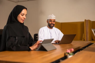 استخدام جهاز التابلت لانجاز المهام، التركيز والعمل المتقن, الحوارات والنقاشات ضمن الفريق,تطوير الاعمال والشركات, اجتماع عمل وانجاز المشاريع, مناقشة الخطط وشرح مهام الاعمال, زملاء عمل عرب عمانيين خليجيين في اجتماع, ارتداء اللباس العماني التقليدي
