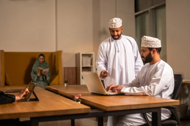 إنجاز المهام بإيماءات الاندماج والبشاشة، التركيز والعمل المتقن, الحوارات والنقاشات ضمن الفريق,تطوير الاعمال والشركات, اجتماع عمل وانجاز المشاريع, مناقشة الخطط وشرح مهام الاعمال, زملاء عمل عرب عمانيين خليجيين في اجتماع, ارتداء اللباس العماني التقليدي