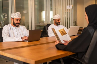 مناقشة الخطط وشرح مهام الاعمال, دمج االتقنية في تطوير الاعمال والشركات, اجتماع عمل لانجاز المشاريع, الحوارات والنقاشات ضمن الفريق, زملاء عمل عرب عمانيين خليجيين في اجتماع, ارتداء الزي العماني التقليدي