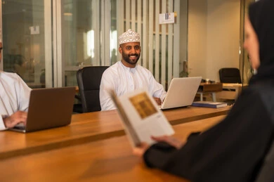 مناقشة الخطط وشرح مهام الاعمال, دمج االتقنية في تطوير الاعمال والشركات, اجتماع عمل لانجاز المشاريع, الحوارات والنقاشات ضمن الفريق, زملاء عمل عرب عمانيين خليجيين في اجتماع, ارتداء الزي العماني التقليدي