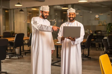 Agreement and partnership on business and commercial projects, acquaintance and friendships, and building social relationships, successful new business deals between businessmen, two Arab Gulf Omanis shaking hands inside the company headquarters with gestures of happiness and joy. Agreement and partnership on business and commercial projects, acquaintance and friendships, and building social relationships, successful new business deals between businessmen, two Arab Gulf Omanis shaking hands insi
