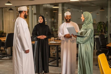 Explanation of the required tasks with happiness and love, cooperation and understanding among the team, exchanging experiences and successful agreements, organizing and managing the work concept schedule, a comfortable work environment in the Omani company, Arab Omani Gulf colleagues discussing the required tasks.