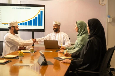 Collaboration and understanding among the team, exchanging experiences and successful agreements, organizing and managing the work concept schedule, a comfortable work environment in the Omani company, explaining the required tasks with happiness and love, a portrait of Arab Omani Gulf colleagues in a meeting to study statistical data, analyzing charts.